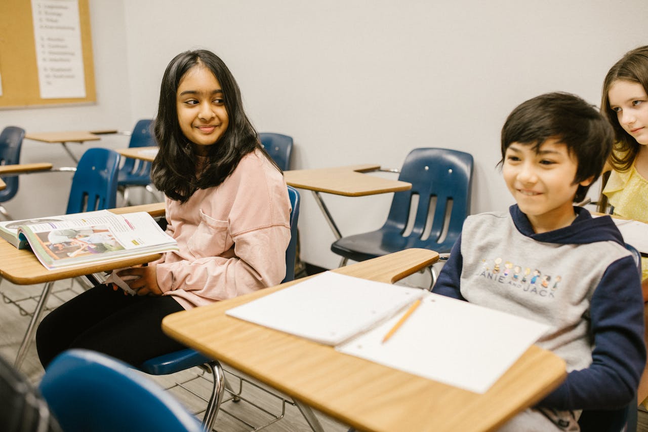 about-01 Students smiling and interacting in a cheerful classroom setting, fostering education and cultural diversity.